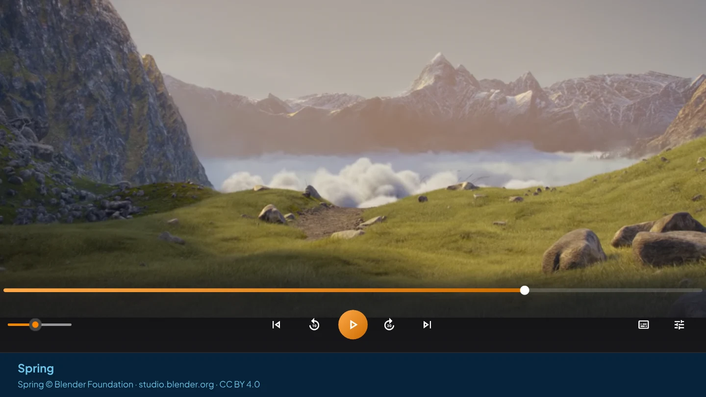 AIX Player showing a green mountain valley with clouds below the peaks, from the Blender film Spring, with its timeline and playback controls visible.